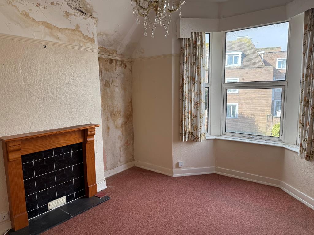 Lot: 125 - SUBSTANTIAL PROPERTY ARRANGED AS TWO FLATS IN NEED OF REFURBISHMENT - FF main bedroom with fireplace and window